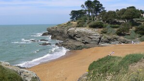 Una spiaggia costiera con scogliere rocciose e una battigia sabbiosa.