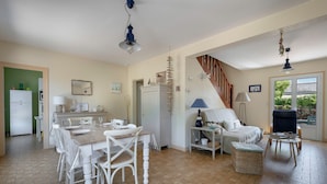 Un vaste espace de vie comprenant une table à manger, des chaises, un canapé et un escalier.