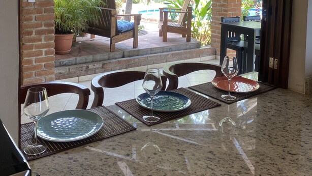 Comedor con vistas al jardín, mobiliario exterior y ventilador de techo.