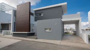 Un edificio moderno de dos pisos con techo plano, ventanas grandes y un diseño minimalista.