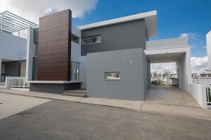Un edificio moderno de dos pisos con techo plano, ventanas grandes y un diseño minimalista.