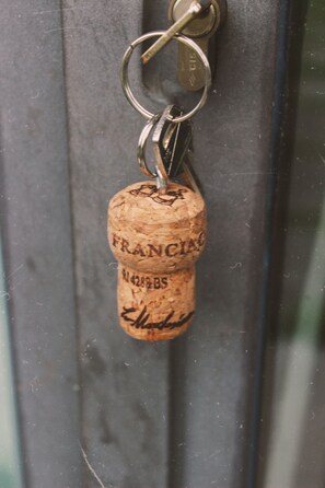 A cork keychain with 'FRANCIA' and '4288BS' engraved on it. - Villa Franca (Passirano)