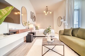 Uma sala de estar moderna com um sofá, mesa de centro e uma TV sobre um console branco.