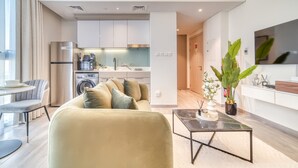 A modern apartment with a living area, kitchen, and dining space.