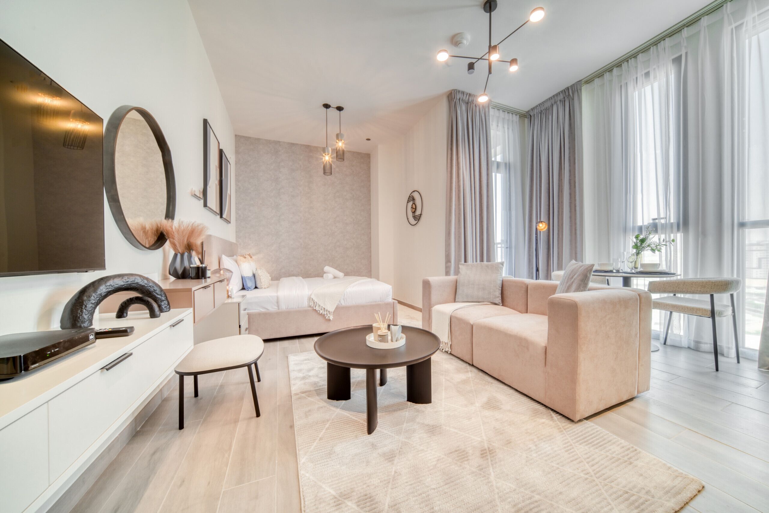 A modern living room with a sofa, armchair, coffee table, and a TV.
