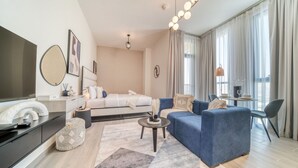 Ein modernes Wohnzimmer mit einer Couch, einem Couchtisch, einem Fernseher und einem Essbereich mit Tisch und Stühlen.