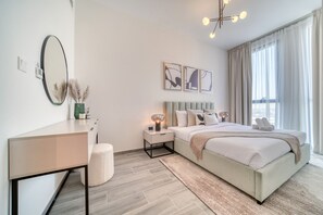 Quarto moderno com cama grande, mesas de cabeceira, espelho e obras de arte na parede.