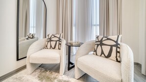 A modern room with two armchairs, a round table, and a large mirror.