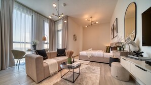 Moderni hotellihuone, jossa on sohva, sänky, sohvapöytä ja suuri peili.
