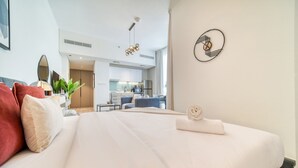 Una camera d'albergo moderna con un letto grande, una scrivania e una angolo cottura sullo sfondo.