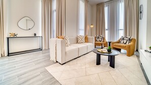 A modern living room with a sofa, armchairs, a coffee table, and a console table.