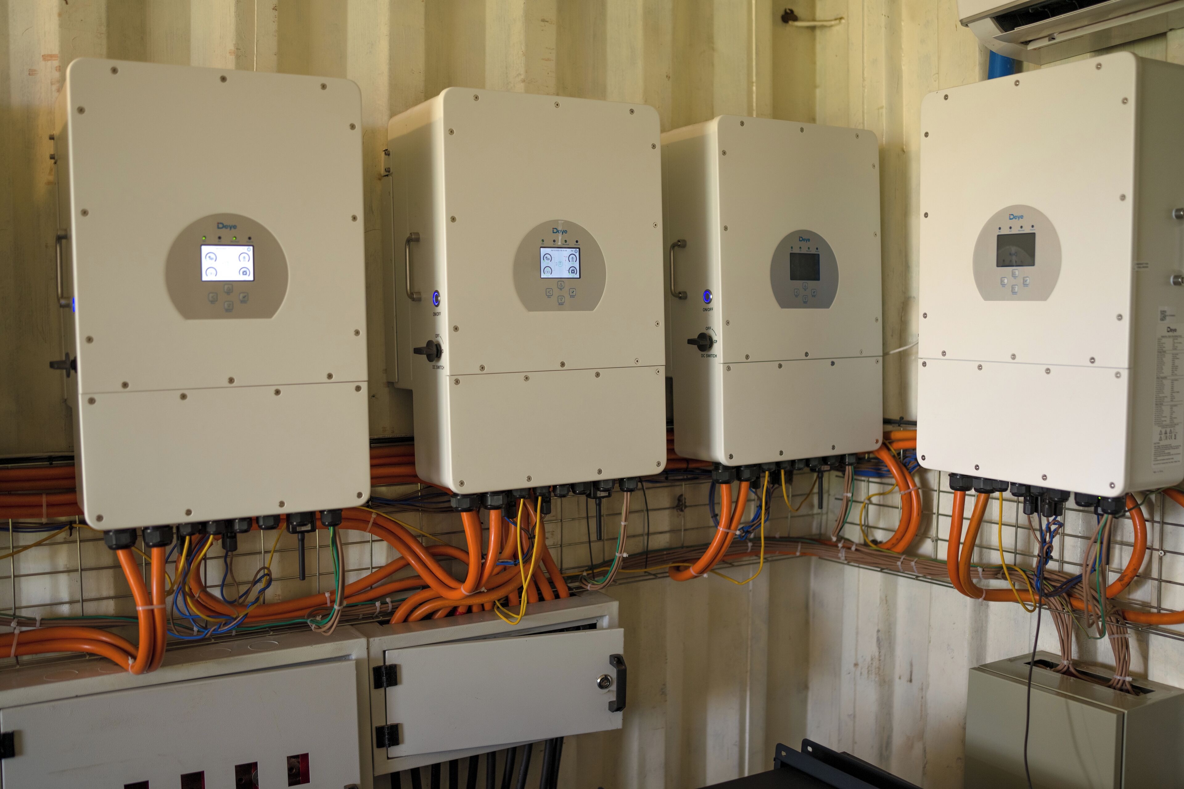 A row of electrical panels with multiple cables connected to them.