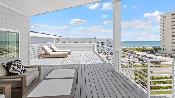 A balcony with a view of the beach, white railings, and lounge chairs. - Seadragon 2 | Pet-Friendly w/ Rooftop Deck + Ocean Views! (Carolina Beach)