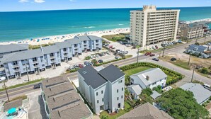 A beachfront hotel with multiple floors, a parking area, and a view of the beach and ocean. - Seadragon 2 | Pet-Friendly w/ Rooftop Deck + Ocean Views! (Carolina Beach)