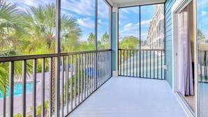 Ein Balkon mit Blick auf einen Swimmingpool und Palmen.