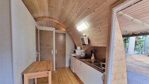 A compact kitchen with wooden cabinets, a countertop, a sink, and a small table. - Nomad Paraiso: Beautiful cozy and familiar bungalow (L'Escala)