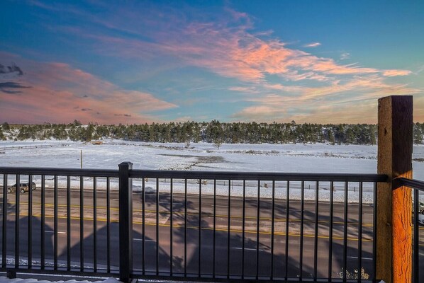 A snowy landscape with a road and a wooden post in the foreground. - Modern Cabin with Spectacular View (Show Low)
