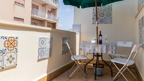 A patio with a table, chairs, and a green umbrella. - Stella Marina apartment, vacation home in Trapani, a few steps from the sea  (Trapani)