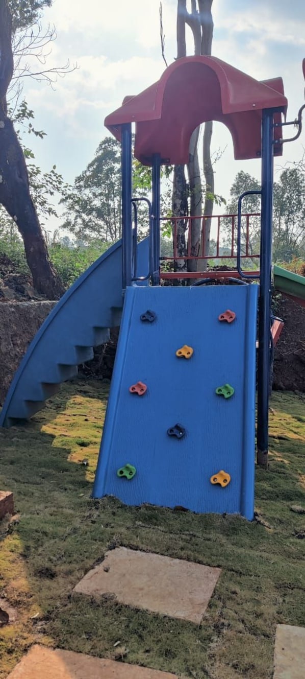 A playground with a blue slide and climbing holds. - Camp Redstart (Leh)