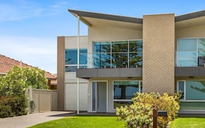 A modern two-story building with large windows, a flat roof, and a brick facade.