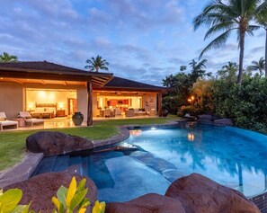 Une maison moderne dotée d’une piscine, de mobilier d’extérieur et d’un jardin bien entretenu.