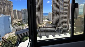A high-rise building with a view of the ocean and other buildings.
