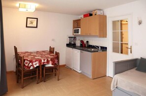 Cozy room with a kitchenette, dining area, and window offering a view of the outside.