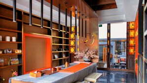 A modern hotel lobby with a reception desk, seating area, and a view of the street through large glass doors. - Wuzhen Dream Hotel (Jiaxing)