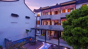 A modern building with a rooftop pool, outdoor seating, and a staircase leading to the upper floors. - Wuzhen Dream Hotel (Jiaxing)