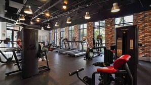 Une salle de sport équipée de tapis de course, d’appareils de musculation et d’un appareil Cybex VR1.