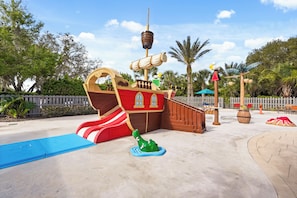 A pirate-themed play area with a slide, a ship-shaped play structure, and a small green frog statue. - Awesome three bedroom townhome near Disney 322 (Davenport)