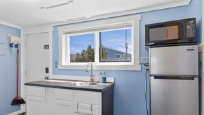 A compact kitchen with a double sink, a microwave, and a refrigerator. - Romantic, Walk to town and beach, Private (ArchView) (Long Beach)