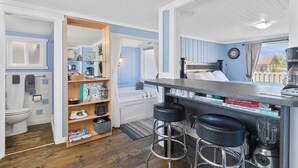 A compact kitchen with a bar area, a built-in bookshelf, and a view of the outside. - Romantic, Walk to town and beach, Private (ArchView) (Long Beach)