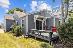 A two-story house with a covered porch and a small deck.