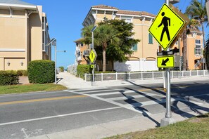 A pedestrian crossing sign and a directional arrow sign on a sunny day. - Spend a month away, just a quick walk to the sand! (Bradenton Beach)
