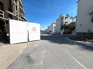 A gated area with a sign for lookouts, a paved road, and multi-story buildings in the background.