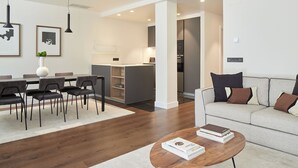 A modern living room with a sofa, coffee table, and dining area. - Elkano by FeelFree Rentals (Donostia)