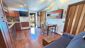 Ein kompakter Wohnbereich mit Küchenzeile, Essbereich und einer Couch.