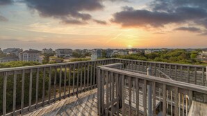 A wooden deck with a view of houses and a sunset. - Near the Beach! Saltwater Pool, Hot Tub, Great Neighborhood, C0949 (Corolla)