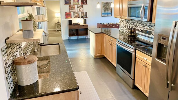 Una cocina moderna con armarios de madera, electrodomésticos de acero inoxidable y una isla central.