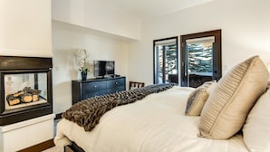 A bedroom with a bed, a dresser, a television, and a fireplace. - Breckenridge White Wolf Townhome 4 Bedroom (Breckenridge)