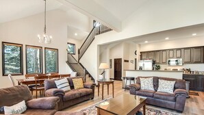 A spacious living room with leather sofas, a wooden coffee table, and a staircase leading to the upper floor. - Breckenridge White Wolf Townhome 4 Bedroom (Breckenridge)