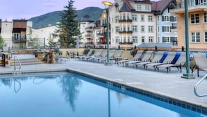 A swimming pool with lounge chairs and a building in the background.