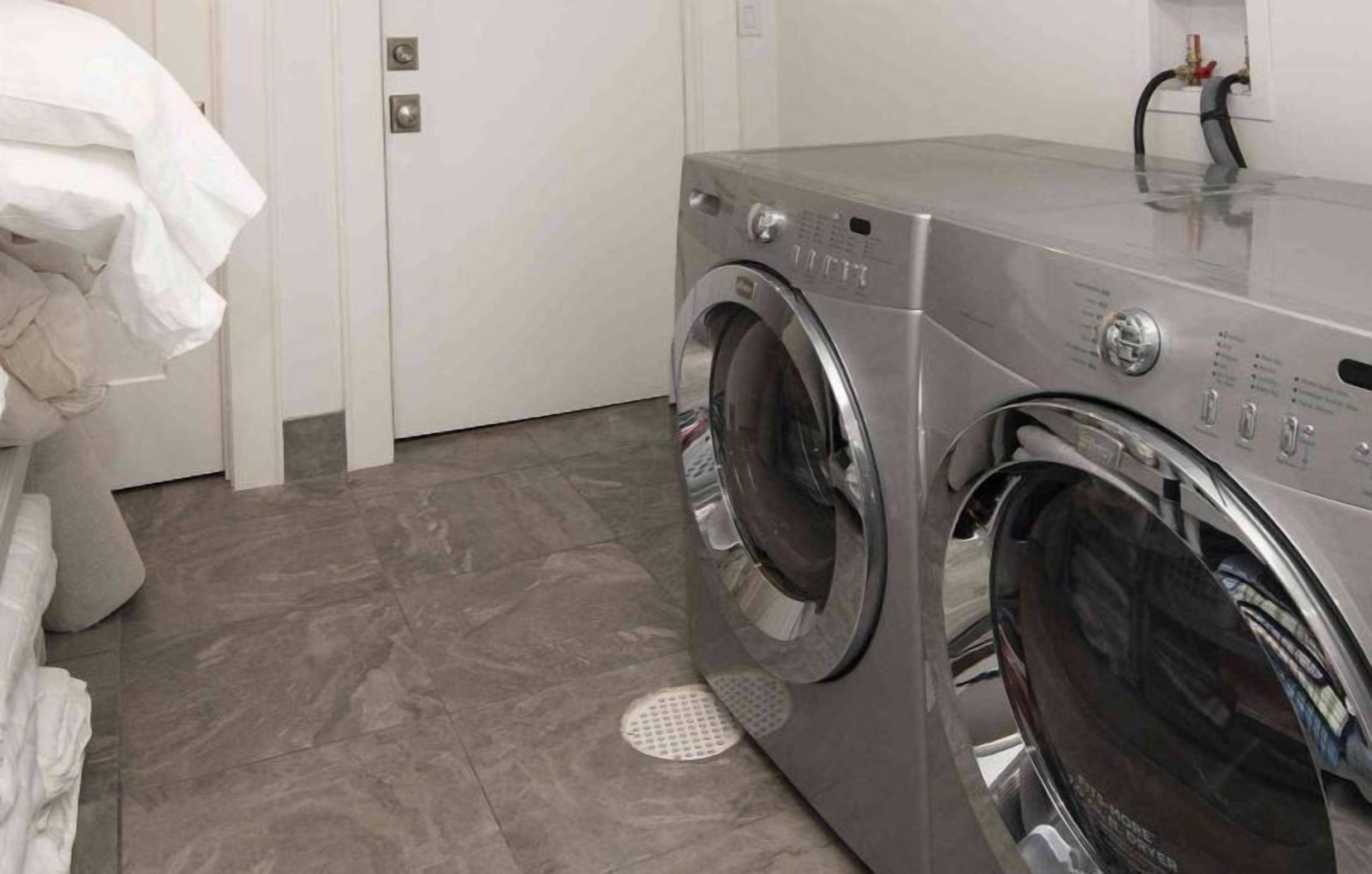 A compact, modern laundry room with a front-loading washing machine and dryer.