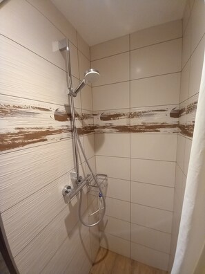Een douche, een haardroger, handdoeken, toiletpapier