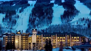 Un hotel grande de varios pisos con un telesilla al fondo.