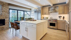 A modern kitchen with a large island, stainless steel appliances, and wooden cabinetry. - Vail - Lionshead Condominiums 2 Bedroom Condo (Vail)