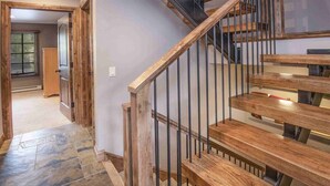 A wooden staircase with metal railings leading to a landing.