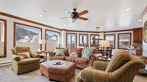 A spacious living room with large windows, a ceiling fan, and a view of a mountain. - Beaver Creek Centennial 2 Bedroom Residence (Avon)