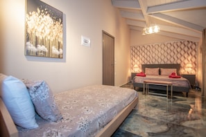 A bedroom with a bed, a bench, and a wall-mounted artwork. - Casa Di Voz (Zakynthos)